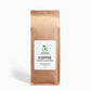 A bag of Mushroom Coffee Fusion (16oz) next to a steaming cup of coffee, representing brain-boosting and immune-supporting benefits.


